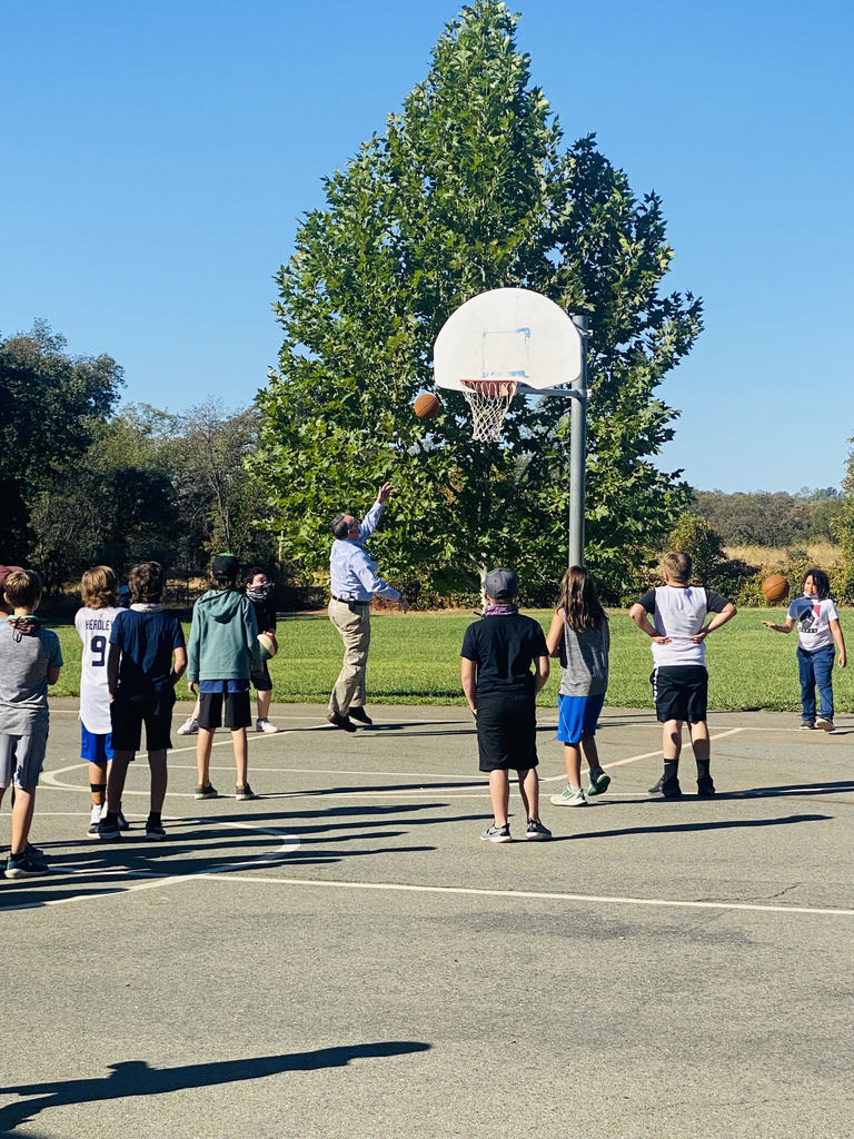 Supt Holtom plays basketball with students.